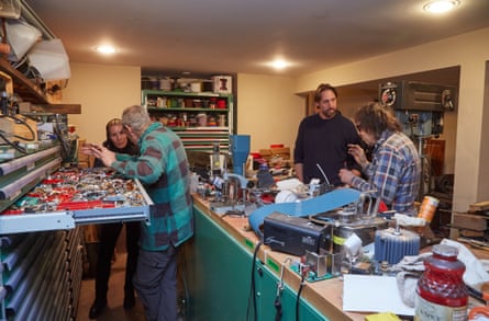 two men explain things to passersby in an electrical engineering room filled with supplies