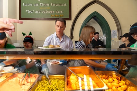 Premier Chris Minns and member for Summer Hill Jo Haylen serve food during a Christmas lunch