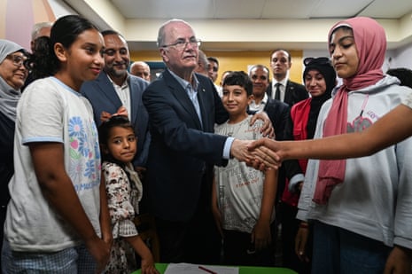Palestinian prime minister Mohamed Mostafa (centre) speaks with relatives of those injured in the Israel-Gaza war at Al-Arish General hospital in Al-Arish, Egypt on 18 August 2025.