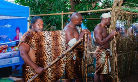 Men standing guard at the entrance to the festival village, armed with spears and dressed in animal skin.