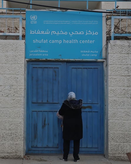 An Unrwa worker locks the gate of clinic in Shuafat refugee camp in East Jerusalem.