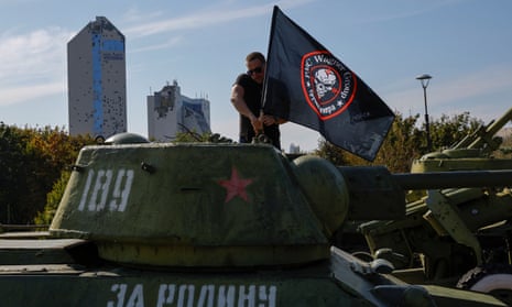 A man attaches a flag to Soviet-era tank at a makeshift memorial for Yevgeny Prigozhin, head of the Wagner mercenary group, and Dmitry Utkin, the group commander, as people mark 40 days since their deaths to respect an Orthodox tradition, in the course of Russia-Ukraine conflict in Donetsk, Russian-controlled Ukraine, October 1, 2023. A sign on a tank read: "For Fatherland".