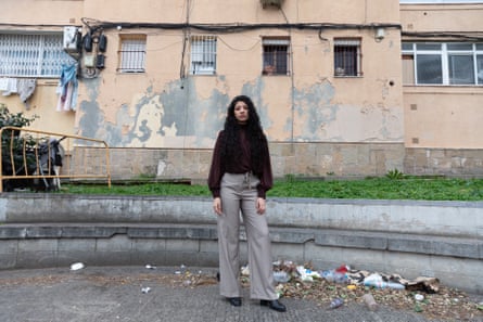 Nada, immaculately turned out, stands outside a dilapidated looking apartment block