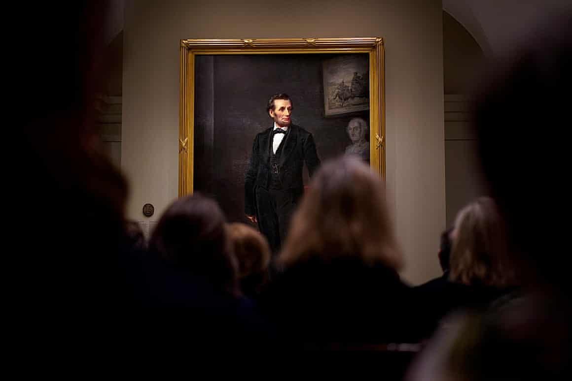 People look at a painting of Abraham Lincoln