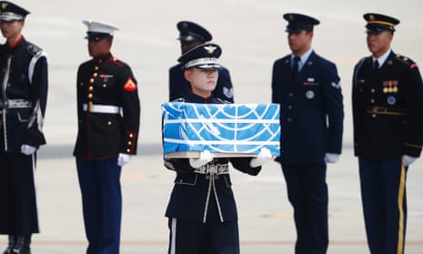 A soldier carries a casket containing the remains of a US soldier killed during the Korean war, after arriving from North Korea at Osan Air Base in Pyeongtaek, South Korea on 27 July.