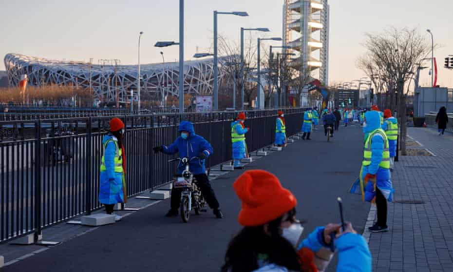 Volunteers line a path outside the closed loop ‘bubble’ surrounding the National Stadium and other venues of the Beijing 2022 Winter Olympics.