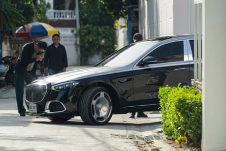A man bows as cars in the convoy of Thailand’s former prime minister Thaksin Shinawatra leave his residence in Bangkok.