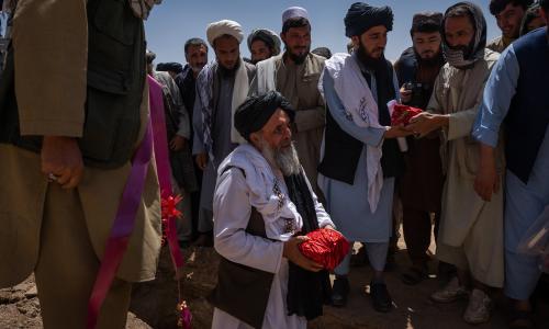 The Taliban-appointed governor of Bamiyan, Abdullah Sarhadi, places the first stone, wrapped in red paper, at the construction site at the historic bazaar of Bamiyan in Bamiyan province, Afghanistan.