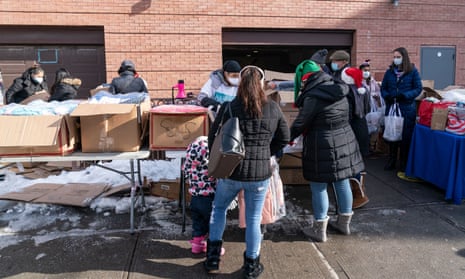 Volunteers distribute holidays toys and winter coats in Corona, Queens, New York, to a line of people stretching seven blocks. Many people lost their jobs and rely on free food and clothing distribution.
