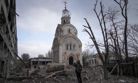 A member of Ukrainian armed force takes a photograph of a damaged church after shelling in Mariupol on Thursday.