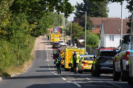 A line of police cars, ambulances, fire engines and other traffic on a two-lane road