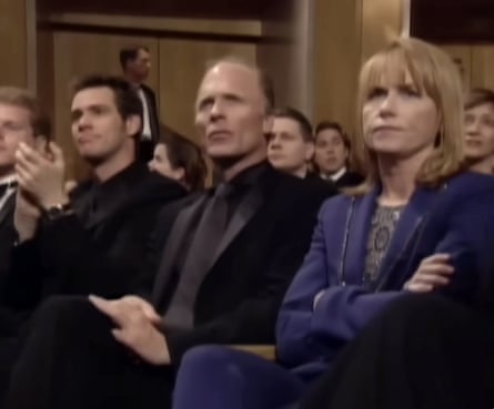 A man and woman sit stony faced at the Oscars.