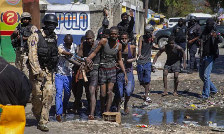 Recaptured inmates are led by police outside the Croix-des-Bouquets Civil Prison after a breakout, in Port-au-Prince, Haiti on 25 February 2021