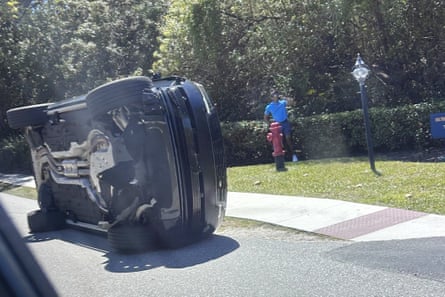 Tiger Woods stands by his overturned Land Rover.