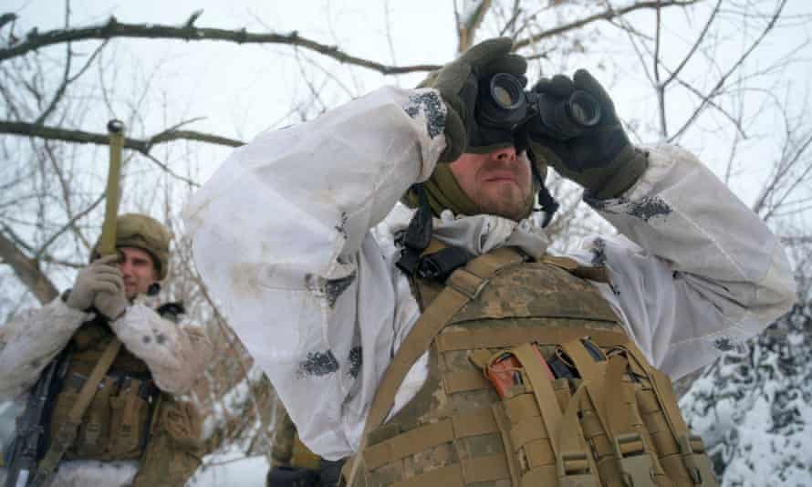 Member of the Ukrainian armed forces looks through binoculars