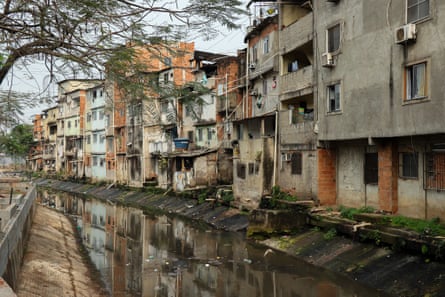 A dirty-looking river running past four or five-storey slum tenements