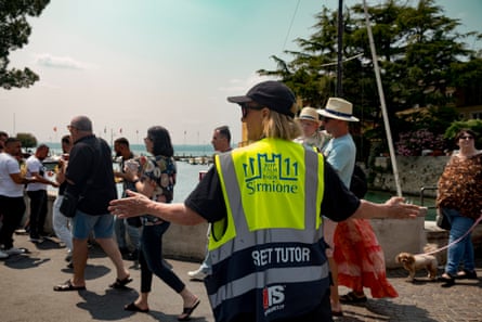 Person in high vis yellow vest directs flow of people