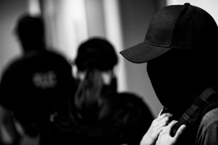 Masked people stand in a hallway