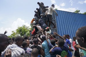 People clamber on to the aid truck in Vye Terre to get food