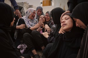 A woman in great distress is held by other women