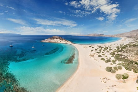 A curved sandy beach by turquoise waters