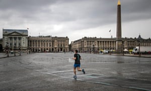 A man jogs across Place de la Concorde