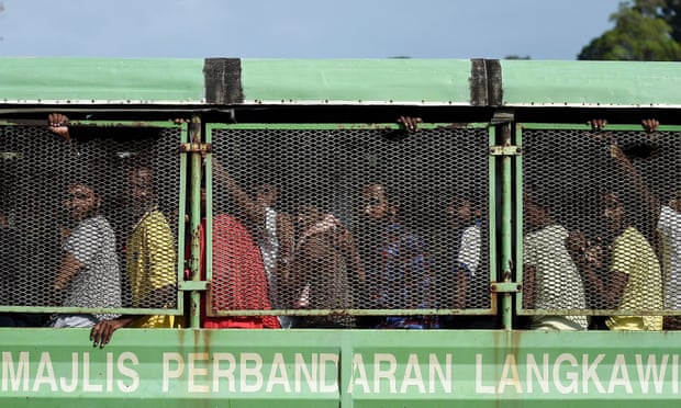 Bangladeshi and Rohingya migrants from Myanmar ride in a truck as they arrive at the naval base in Langkawi to be transferred to a mainland immigration centre.
