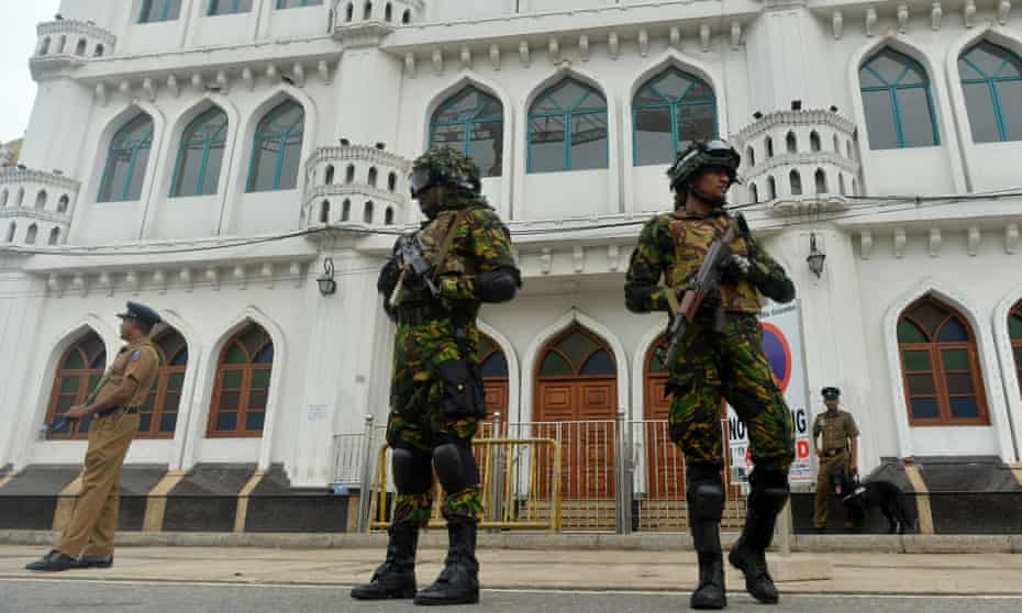 Security personnel stand guard outside a mosque during Friday prayers in Colombo