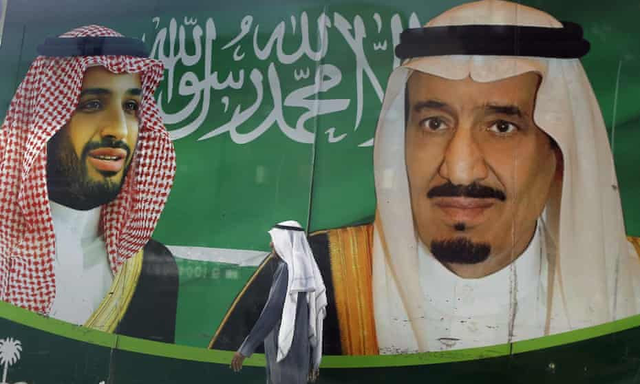 A man walks past a banner showing King Salman, right, and Crown Prince Mohammed bin Salman, outside a mall in Jiddah, Saudi Arabia. 