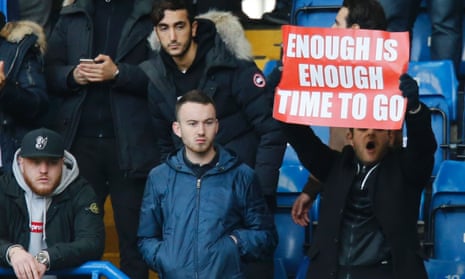 An Arsenal fan holds up a banner calling on Arsène Wenger to quit during the team’s defeat at Chelsea.