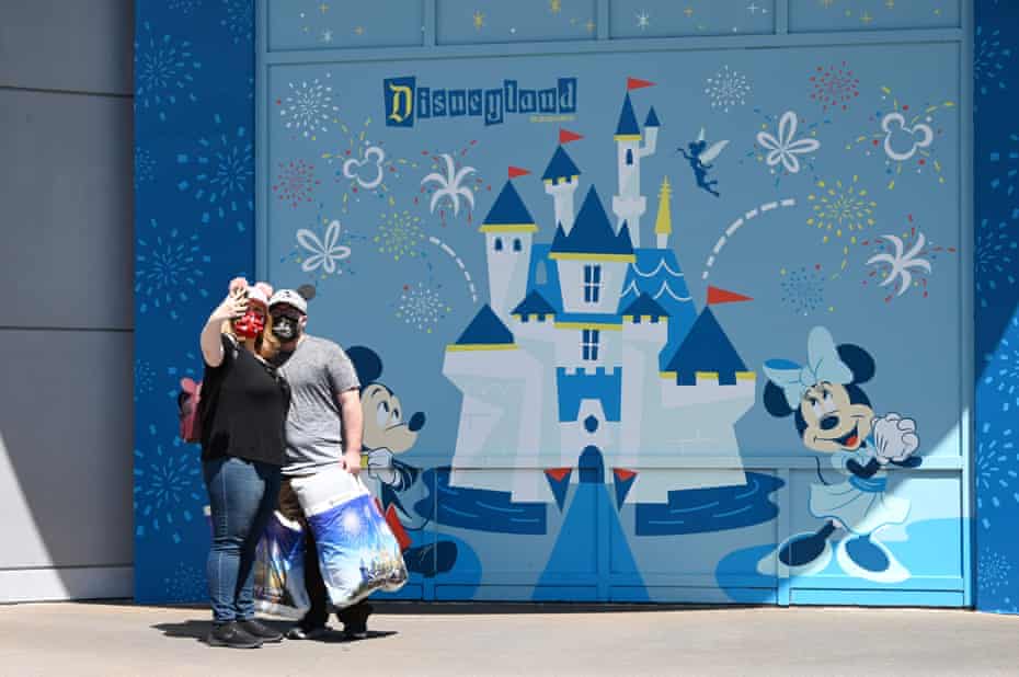 People take a selfie while visiting Downtown Disney on 9 July, the first day the outdoor shopping and dining complex was open to the public since it closed in mid-March amid the Covid-19 pandemic.