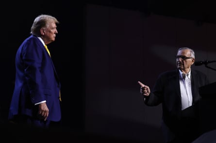 a man in a suit points at another man in a suit