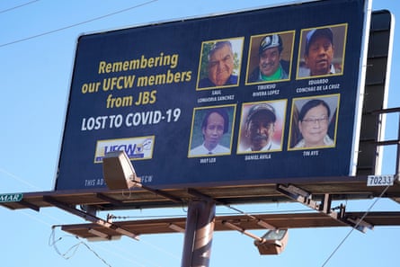 A highway billboard bears the images of the six employees who died of Covid-19 while employed at the JBS meatpacking plant in Greeley.