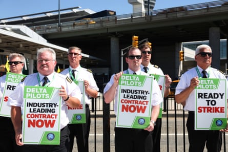 people clasp signs that publication ‘Delta pilots industry-leading statement now’