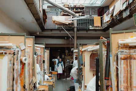 Madame Van der Kelen enters the workshop.