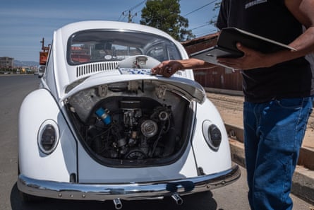 A man looks at the engine compartment of a newly restored VW Beetle
