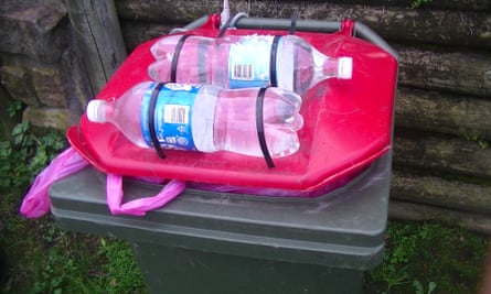 Full water bottles strapped to a bin lid using zip ties