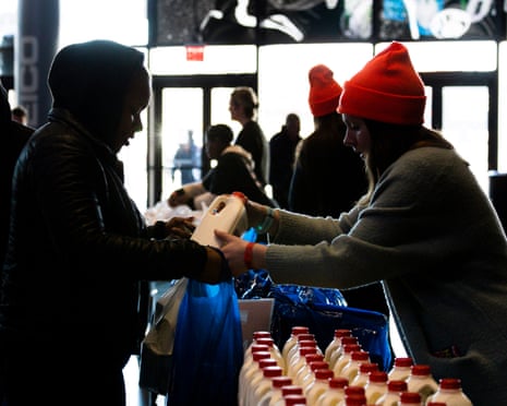 A person collects milk and food from Food Bank employee at a food donation site set up for furloughed federal workers in January 2019.