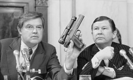 black and white photo of a man holding up a gun and another man next to him