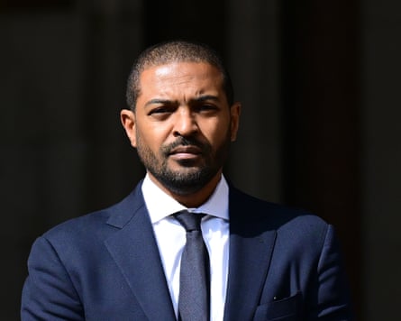 Noel Clarke in blue jacket and tie