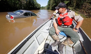 North Carolina wildlife resources commission officers search by boat for those in need of rescue as river waters rise dangerously after Hurricane Matthew.