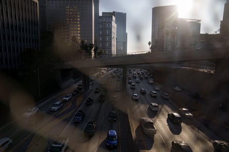 cars on a highway with city buildings behind