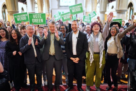 Zack Polanski with party candidates and supporters holding ‘Vote Green’ banners inside a church where he gave a speech