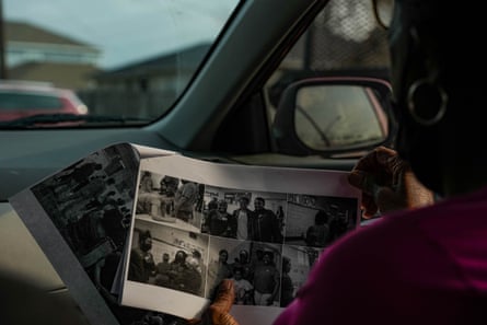 A woman looks at a book of photos in side a car