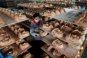 A worker checks a mask in quality control