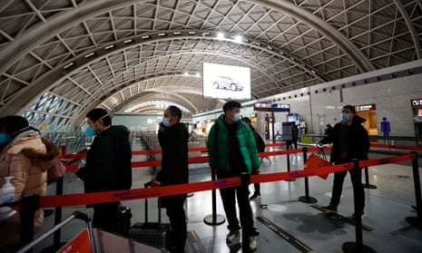 Travellers queue to board a plane at Chengdu airport in China