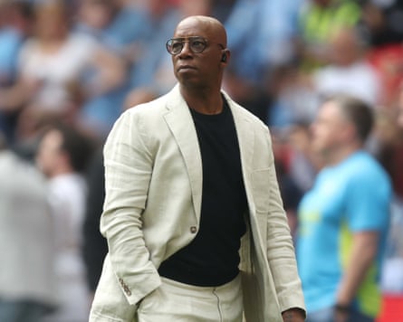 Ian Wright in a cream suit and glasses on at Wembley Stadium