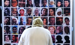 A bereaved relative looks at pictures of the Grenfell Tower fire victims during a press conference by Grenfell Next of Kin group on Wednesday.