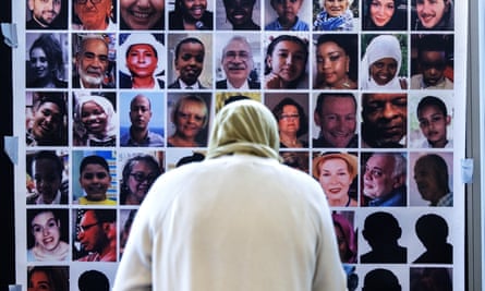 A bereaved relative looks at pictures of the Grenfell Tower fire victims during a press conference by Grenfell Next of Kin group, 4 September 2024