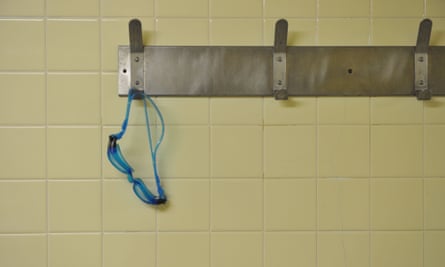 A photograph of swimming goggles hanging on a changing room peg. 